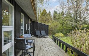 a porch with chairs and a table on a house at 3 Bedroom Cozy Home In Gilleleje in Gilleleje