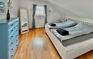 a bedroom with a white bed and a blue dresser at Beautiful Apartment In Uggdal With House Sea View in Uggdal