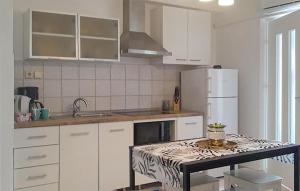 a kitchen with white cabinets and a counter top at 2 Bedroom Amazing Home In Valbandon in Štinjan