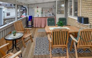 Amazing Home In Vstervik With Heated Swimming Pool في فاسترفيك: شرفة مع طاولات وكراسي خشبية ومكتب