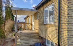 韦斯特维克Gorgeous Home In Västervik With Wifi的一座带木制楼梯的房屋,通往门廊