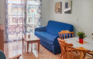 - un salon avec un canapé bleu et une table dans l'établissement Stunning Apartment In San Pedro Del Pinatar With Wifi, à San Pedro del Pinatar