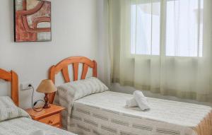 Cette chambre dispose de deux lits, d'une chaise et d'une fenêtre. dans l'établissement Stunning Apartment In San Pedro Del Pinatar With Wifi, à San Pedro del Pinatar