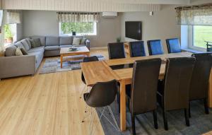 a living room with a wooden table and chairs at Amazing Home In Lderup With Wifi in Löderup