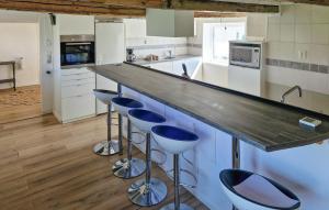a kitchen with blue bar stools and a counter at Amazing Home In Lderup With Wifi in Löderup