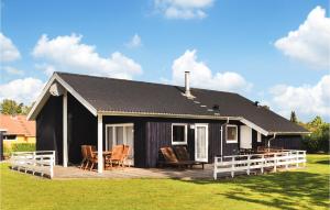 una casa negra con terraza y sillas en Stunning Home In Sydals With Kitchen, en Skovbyballe
