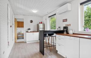 a kitchen with white cabinets and a black counter top at 2 Bedroom Stunning Home In Vinderup in Vinderup +11 photos