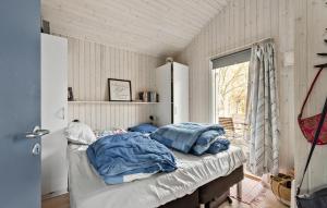 a bedroom with a bed with blue sheets and a window at Stunning Home In Dronningmlle With Wifi in Dronningmølle