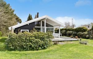 a black house with a porch and a lawn at Stunning Home In Dronningmlle With Wifi in Dronningmølle