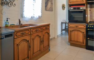 a kitchen with wooden cabinets and a sink and a microwave at Gorgeous Home In Marcillac-La-Croisille in Marcillac-la-Croisille