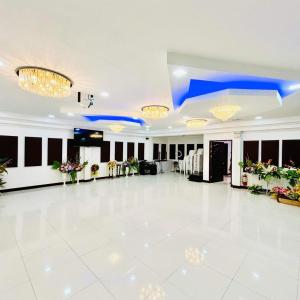 um grande salão de banquetes com piso branco e lustres em Offshore Hotel em General Santos