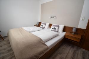 ein Bett mit zwei Kissen auf einem Zimmer in der Unterkunft Landhaus Bichlbach in Bichlbach
