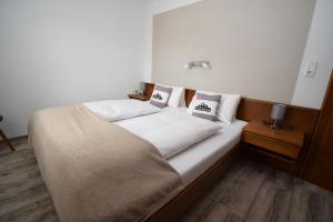 a bed with two pillows on it in a room at Landhaus Bichlbach in Bichlbach