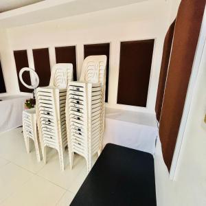een groep witte stoelen in een kamer met ramen bij Offshore Hotel in General Santos