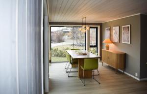 a dining room with a table and green chairs at Nice Home In Sandefjord With House Sea View in Sandefjord
