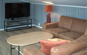 sala de estar con sofá, mesa y TV en Nice Home In Sandefjord With House Sea View, en Sandefjord