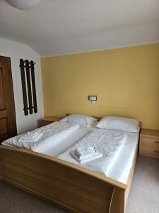 1 dormitorio con 1 cama grande con sábanas blancas en Ferienhaus Sinning, en Leogang