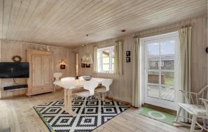 a dining room with a table and a television at Beautiful Home In Blåvand With Wifi in Blåvand