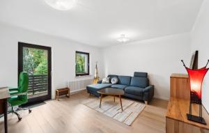 a living room with a blue couch and a table at Ferienhaus 2 Schlafzimmer in Bad Zwischenahn