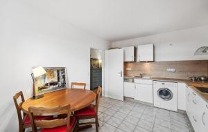 a kitchen with a dining room table and a washing machine at Ferienhaus 2 Schlafzimmer in Bad Zwischenahn