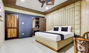 a bedroom with a bed and a blue wall at FabHotel Prime Grand Ali in Srinagar