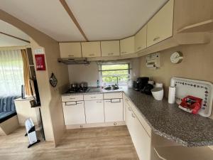 a kitchen with white cabinets and a counter top at Bospark Lunsbergen - LB 50 in Borger