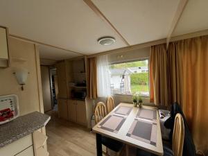 a kitchen and dining room with a table and a window at Bospark Lunsbergen - LB 50 in Borger