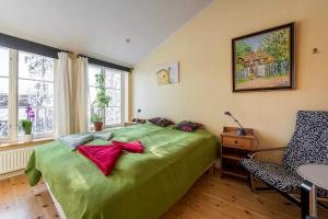 Un dormitorio con una cama verde y una silla en B&B Eco-Village 12 min from city en Estocolmo