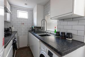 a kitchen with a sink and a washing machine at 4 Bed House Contractor & Leisure in Preston