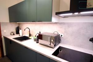 a kitchen counter with a toaster and a sink at HOMELY STAY - Serenity Greens Studio in Munich