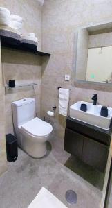 a bathroom with a white toilet and a sink at Modern design 1br in downtown Luanda in Luanda