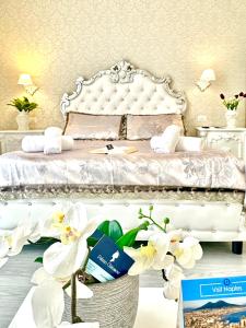 1 dormitorio con 1 cama blanca y orquídeas blancas en Palazzo Chiatamone, en Nápoles