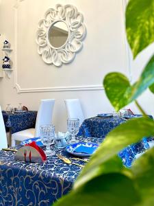 einen blauen und weißen Tisch mit einem Spiegel an der Wand in der Unterkunft Palazzo Chiatamone in Neapel
