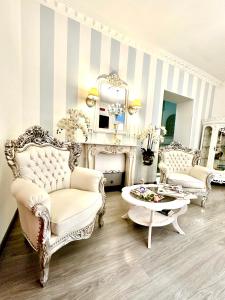 ナポリにあるPalazzo Chiatamoneのリビングルーム(白い椅子、テーブル付)