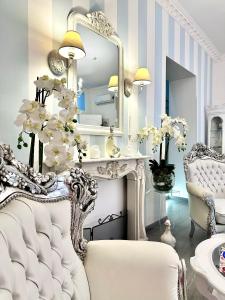 a white room with a mirror and a chair at Palazzo Chiatamone in Naples