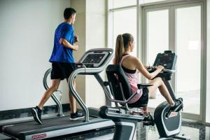 a man and a woman on a treadmill in a gym at Muong Thanh Holiday Muine Hotel in Mui Ne