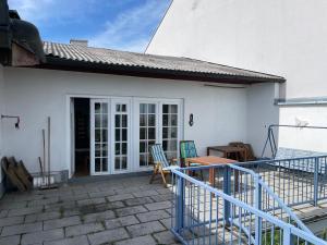 a white house with a patio with a table and chairs at Villa Vista Pannonia in Donnerskirchen