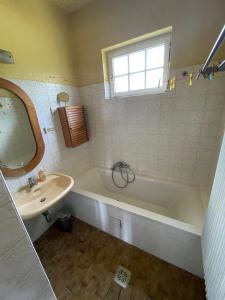 baño con bañera, lavabo y ventana en Villa Vista Pannonia, en Donnerskirchen