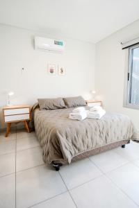 een witte slaapkamer met een bed en een raam bij 5- Fantastico duplex centrico! in Mendoza