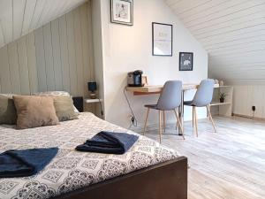 Schlafzimmer mit einem Bett, einem Tisch und Stühlen in der Unterkunft Studio Miraumont, stationnement gratuit, 5min gare in Amiens