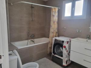 ein Badezimmer mit einer Badewanne, einem WC und einer Waschmaschine in der Unterkunft Hammamet (Zone Les Orangers Hotel) in Hammamet Sud