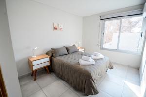 een slaapkamer met een bed met een nachtkastje en een raam bij 5- Fantastico duplex centrico! in Mendoza