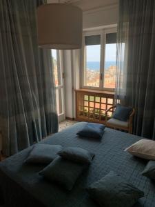 een slaapkamer met een bed met kussens en een raam bij Beautiful Penthouse Sea View - Private Terrace in Maiori