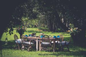 a wooden table with chairs around it in the grass at Mukima Manor in Nanyuki