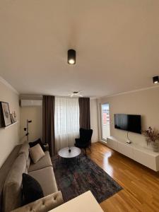 a living room with a couch and a flat screen tv at Latea luxury apartment in Lukavica