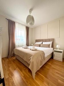 a bedroom with a large bed and a large window at Latea luxury apartment in Lukavica