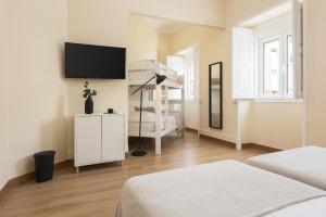 een slaapkamer met 2 bedden en een tv aan de muur bij City Rooms - Amesterdao - Private room by HD in Faro
