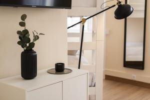 een bureau met een lamp en een vaas met een plant bij City Rooms - Amesterdao - Private room by HD in Faro