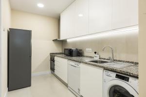 een keuken met een wasmachine en een wastafel bij City Rooms - Amesterdao - Private room by HD in Faro