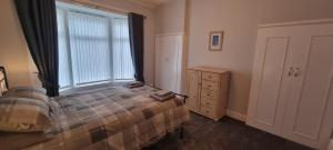 a bedroom with a bed and a window and a dresser at Traditional 3-Bed House on the Historic Headland in Hartlepool